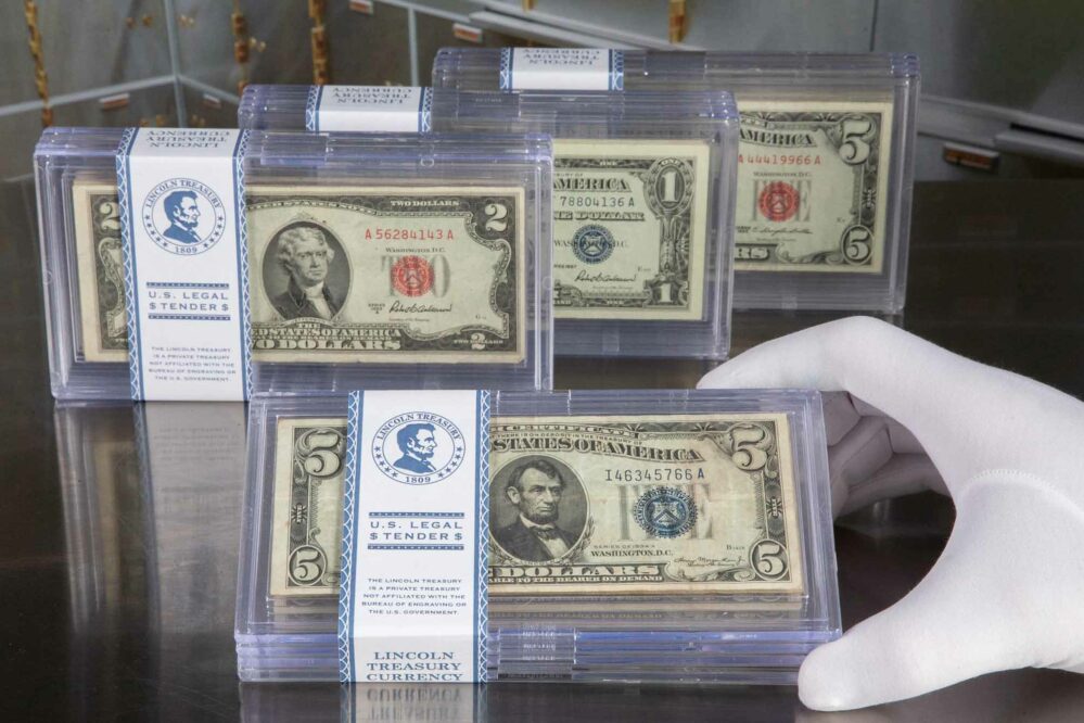 Multiple Sets of Blue and Red Seal Collections, "U.S. Legal Tender" - Lincoln Treasury, White-gloved hand holding one set.