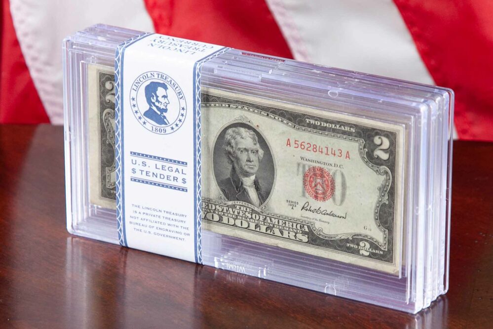 Set of Blue and Red Seal Collection, "U.S. Legal Tender" - Lincoln Treasury, Sitting on a wooden tabletop with US Flag in background.