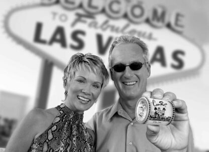 Couple holding a Casino Roll in front of the "Welcome to Las Vegas Sign"